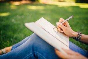 Person Writing on Notepad
