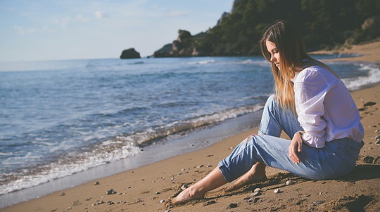 Girl sitting on beach.